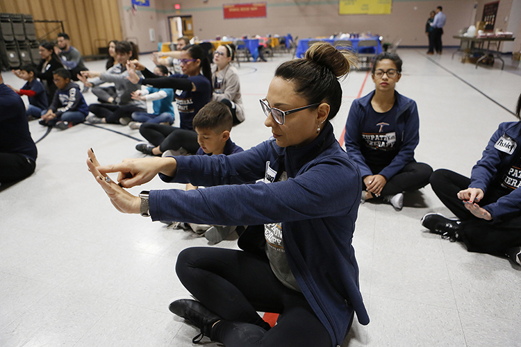 UTEP occupational therapy student Clarissa Medrano practices meditation and yoga with students at Robbin E.L. Washington Elementary School. Photo: J.R. Hernandez/UTEP Communications 