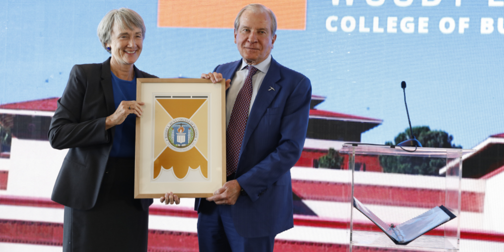Woody L. Hunt and a UTEP representative holding a framed college naming gift.