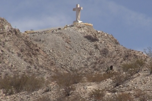 An unidentified man hides in the bushes near the top of Mount Cristo Rey, which straddles the U.S.-Mexico border between Juarez, Mexico and Sunland Park, New Mexico. (Border Report photo)