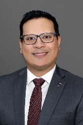 Portrait of Dr. Mendez wearing a white button down shirt, burgundy pattern tie, and navy blue sportcoat.