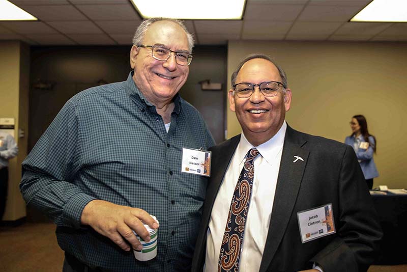 Dale Nasser and Jacob Cintron posing together at the Loya Engineering 2022 Homecoming breakfast with one person holding a cup.