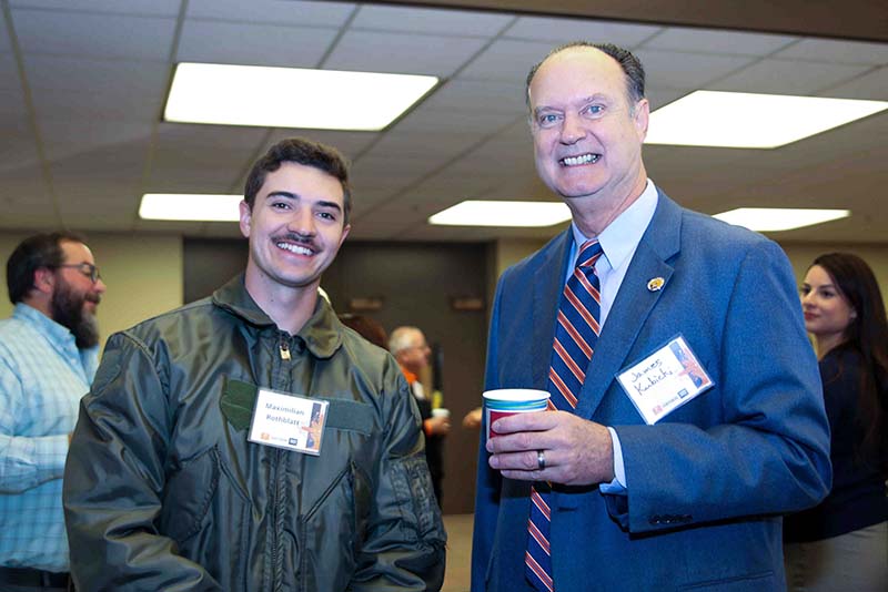 Maximilian Rothblatt and James Kubicki posing together at the Loya Engineering 2022 Homecoming breakfast with one person holding a cup.