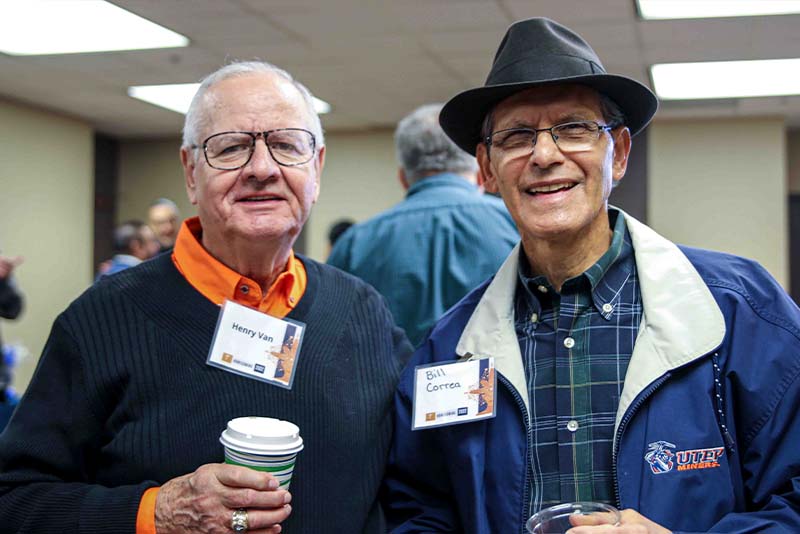 Henry Van and Bill Correa posing together at the Loya Engineering 2022 Homecoming breakfast while holding beverage cups.