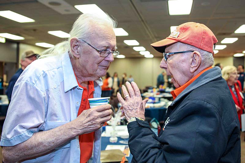 Two people talking to each other during the Loya Engineering 2022 Homecoming breakfast.
