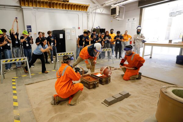 Mining Camp participants watching an indoor hands-on mining demonstration.