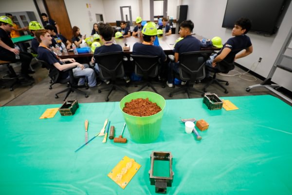 Mining Camp participants seated around a table during a hands-on classroom activity.