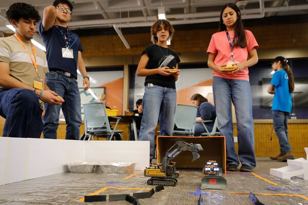 Mining Camp students observing a mine operation model during a hands-on activity.