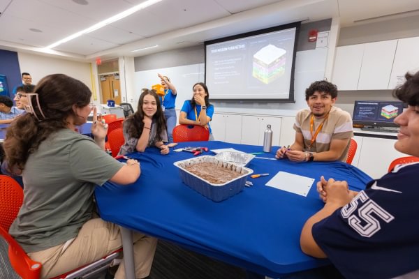 Mining Camp students participating in a group discussion around a classroom table.