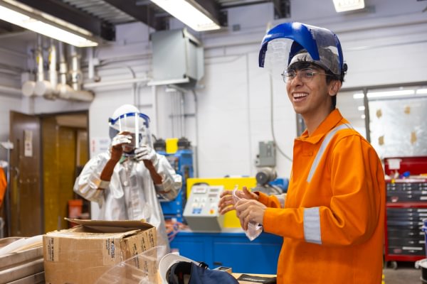 A Mining Camp participant wearing protective gear during a foundry safety demonstration.