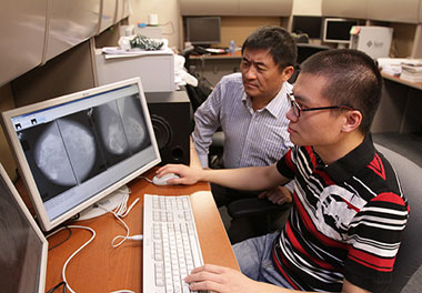 Wei Qian, Ph.D., left, professor of electrical engineering, is working with doctoral student Wenqing Sun to create a breast cancer prediction system.