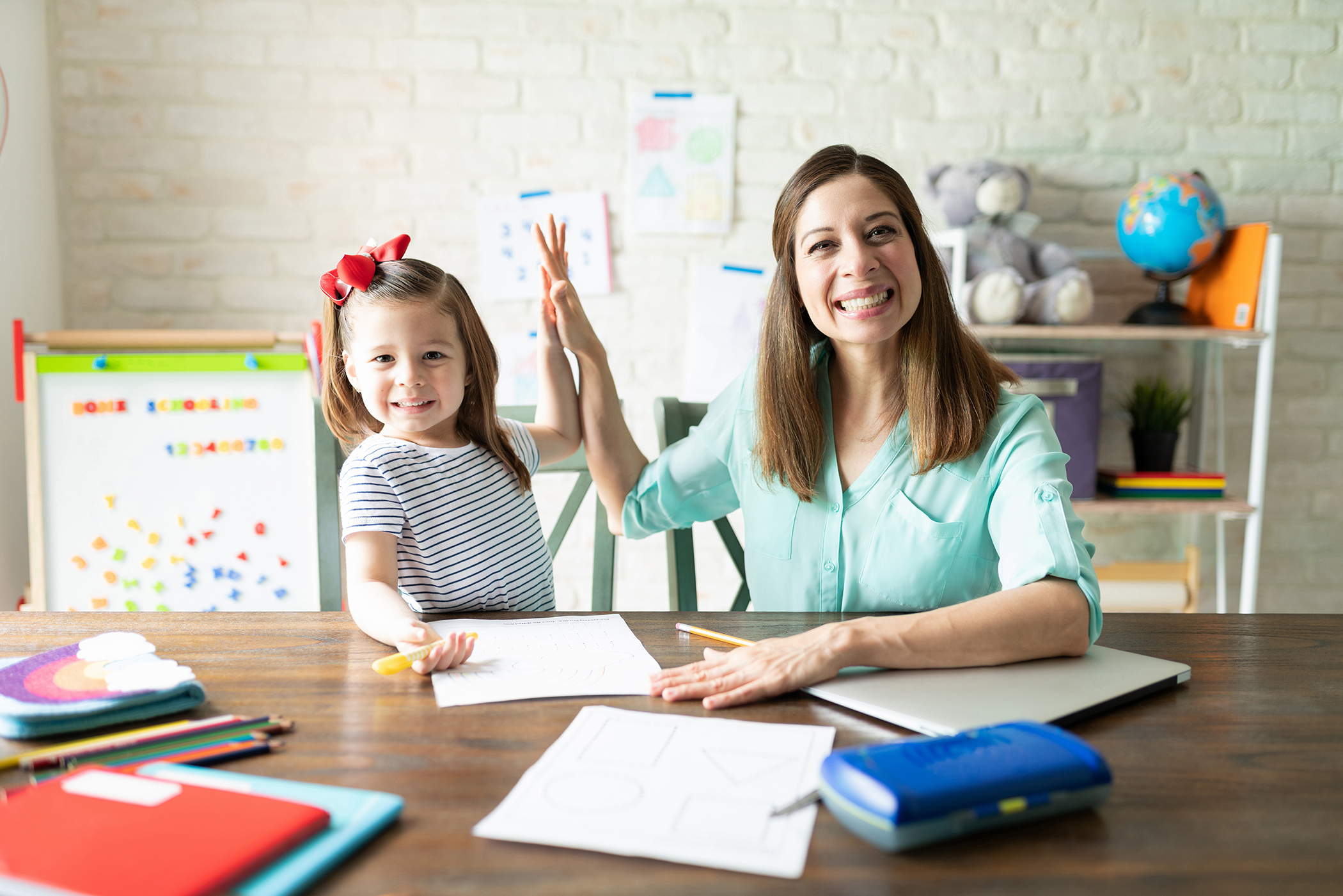 Female early childhood teacher smiling with child