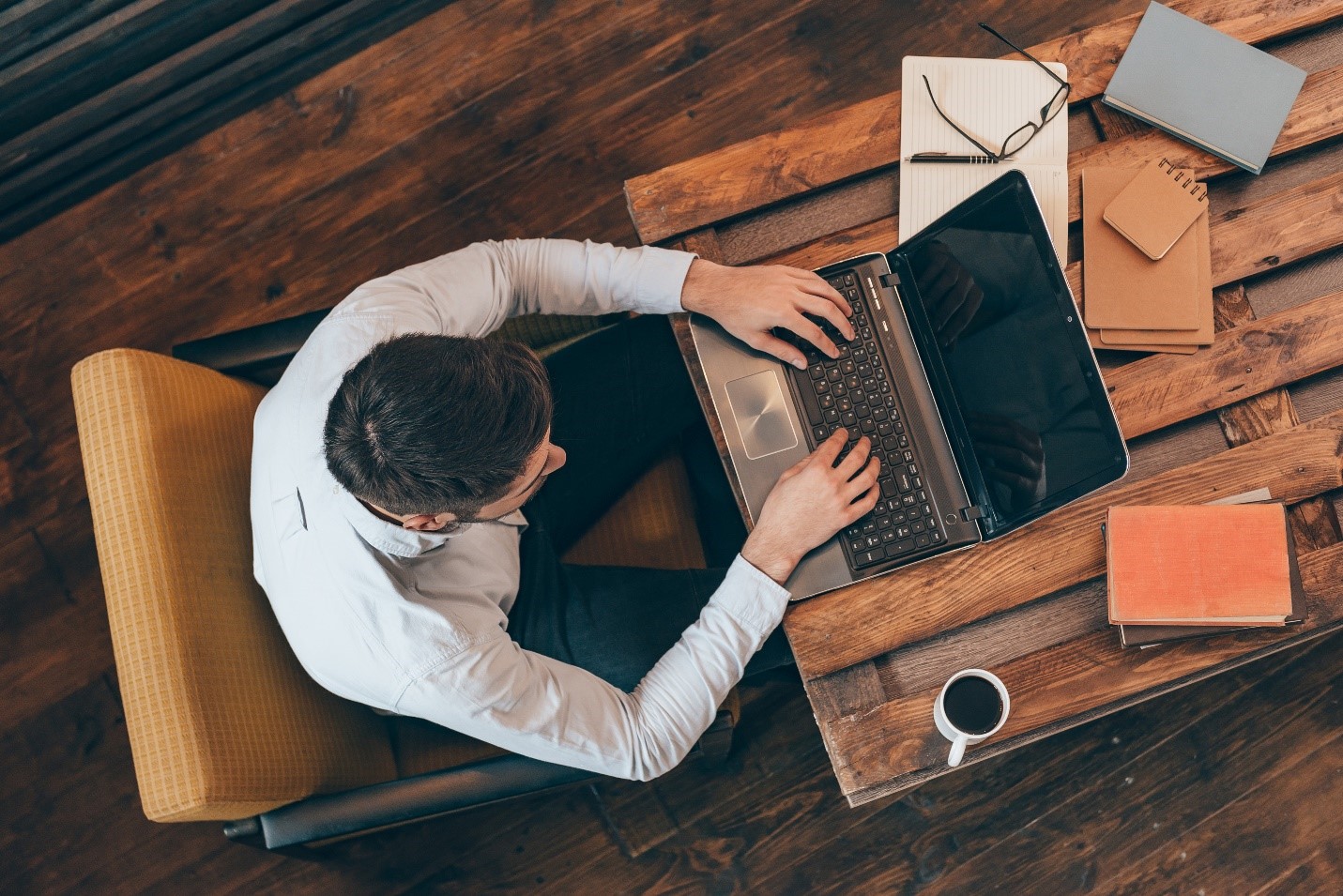 Overhead image of a professional adult working on a laptop