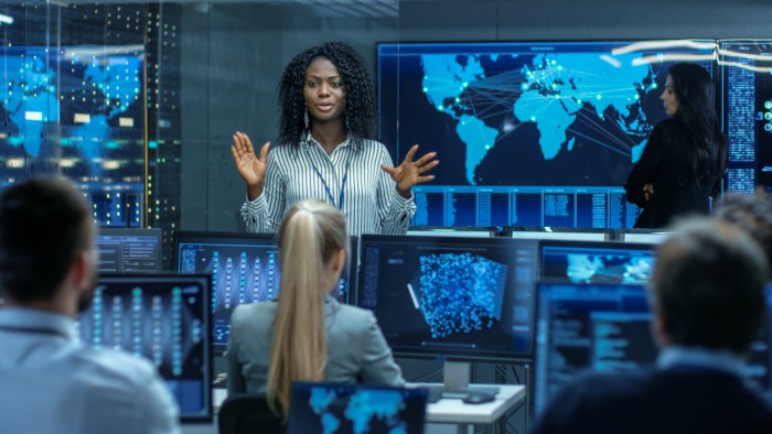 Chief systems engineer holds a briefing for a team of engineers. 