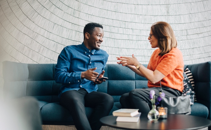 A man and a woman sitting on a coach, networking | UTEP Connect