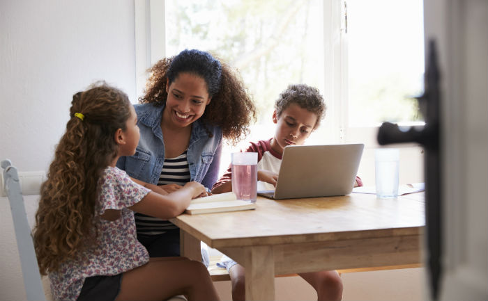 Mother sitting at table with son and daughter and talking about creating a study schedule.