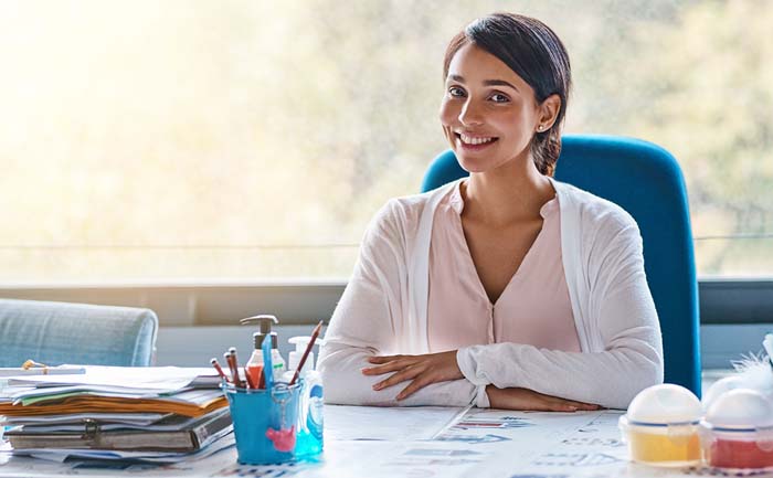 Portrait of a young female teacher marking papers inside of her classroom.