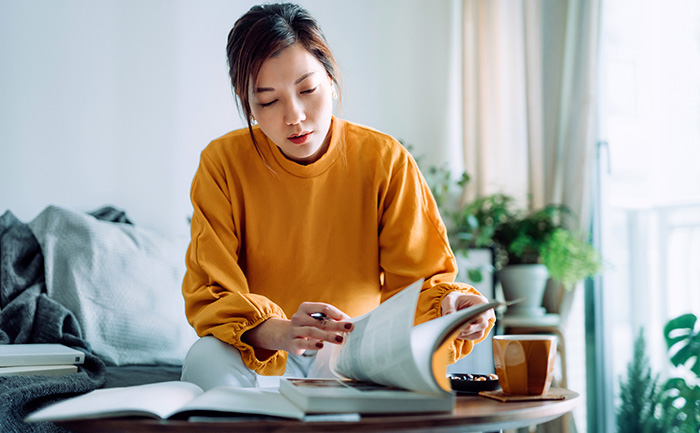 Portrait of a woman studying on her couch at home.