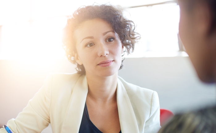 Business woman jotting down notes in an interview setting