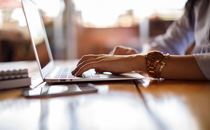 A close-up of a person working a laptop computer | UTEP Connect