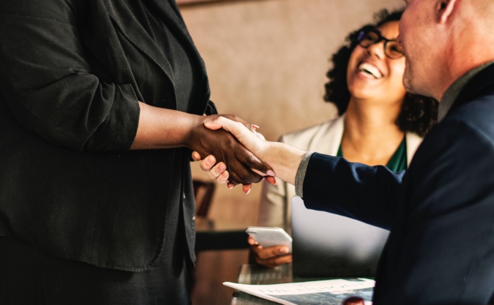 An interviewee shaking hands with an employer after a successful job interview