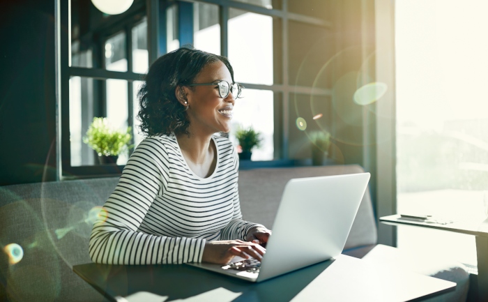 African-American woman smiling while sitting in front of her laptop | UTEP Connect