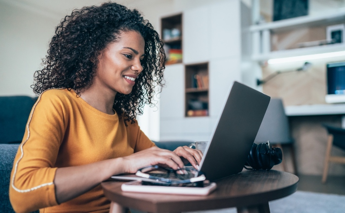 Young woman working or studying online on a laptop in her living room | UTEP Connect