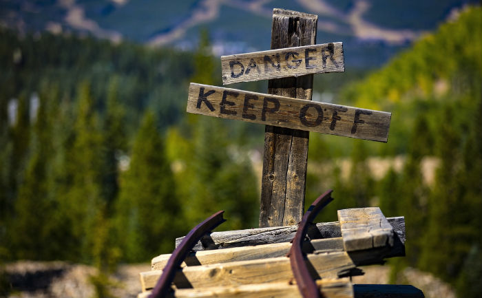 A broken railroad track veers into the distance with a sign that says Danger Keep Off.