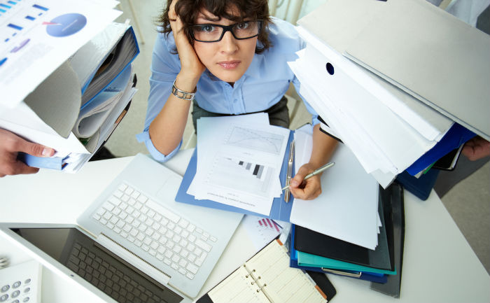 Woman overwhelmed by papers for online education.