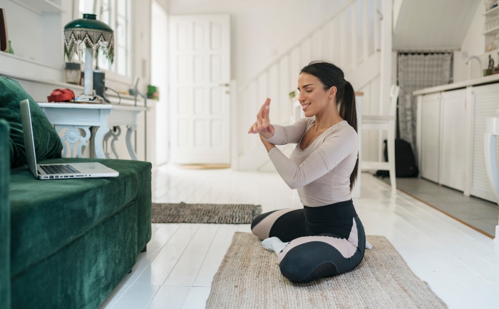 Young woman in activewear warming up at home for exercises online | UTEP Connect