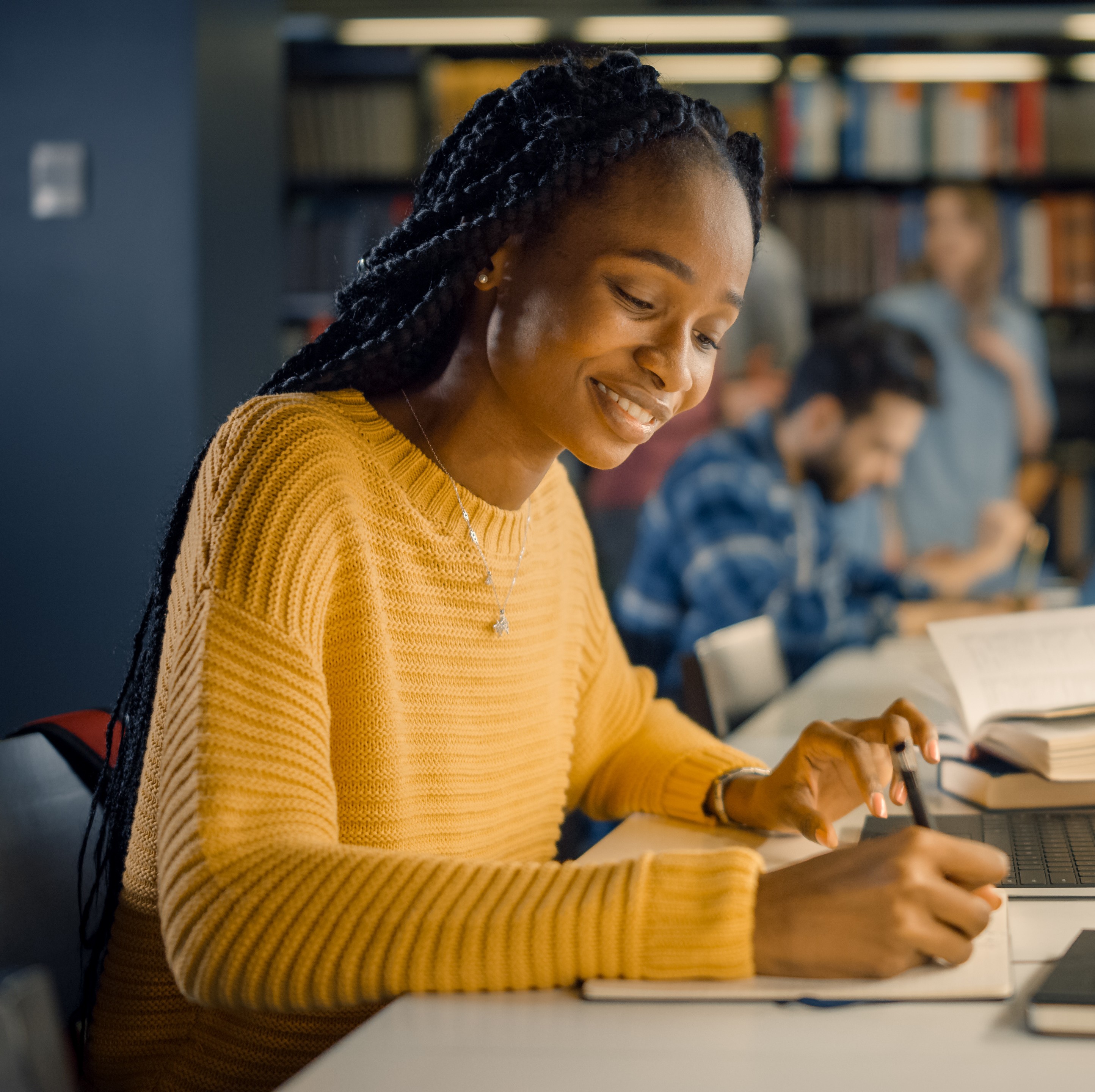Female using laptop and writing notes