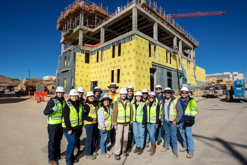 The UTEP campus is growing - and the team behind these transformations is comprised of many UTEP alumni. Pictured here, the alumni working to construct the new Advanced Manufacturing and Aerospace Center pose with President Heather Wilson before taking her on a hardhat tour of the building. 