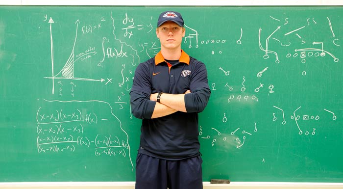 UTEP quarterback Ryan Metz stands in front of a chalkboard where he solved math problems and drew up football plays. Metz is a math major with a concentration in secondary education. Photo: J.R. Hernandez / UTEP Communications 