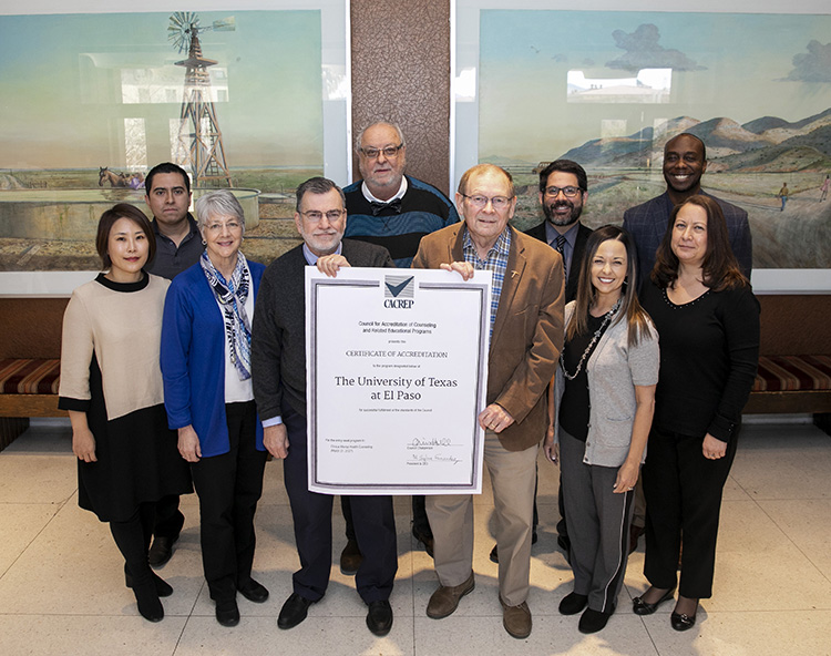 Craig Williams, Ph.D., center left, and Rick Myer, Ph.D., hold an enlarged copy of the accreditation certificate from the Council for Accreditation of Counseling and Related Educational Programs. Standing with them are faculty members and staff from UTEP's Department of Educational Psychology and Special Services. 